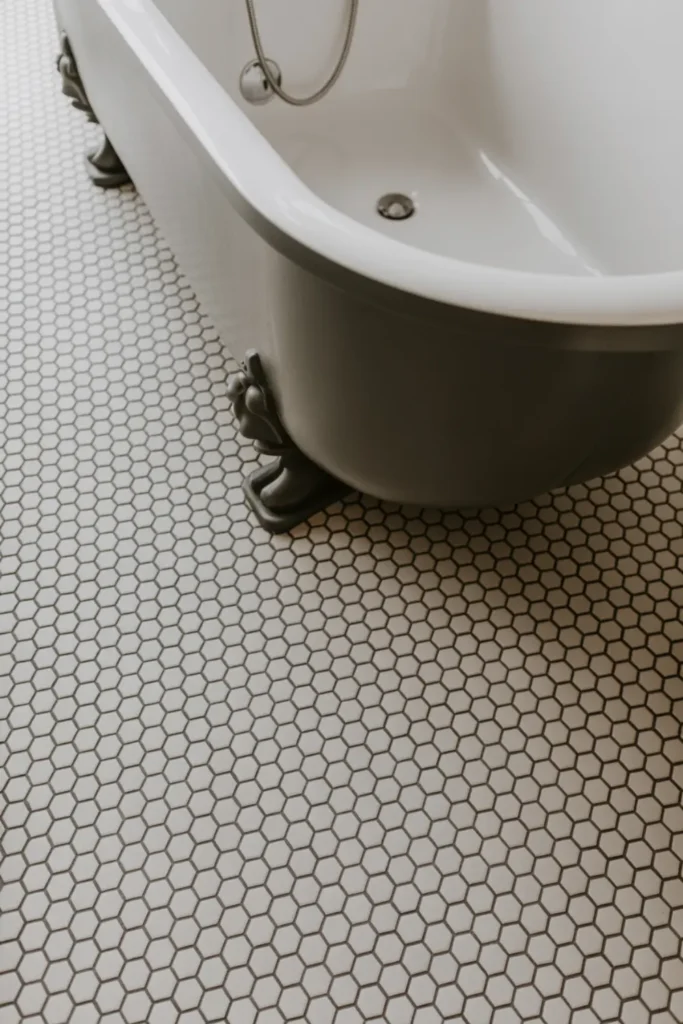 Classic black and white hexagon floor tiles under a matte black bathtub.