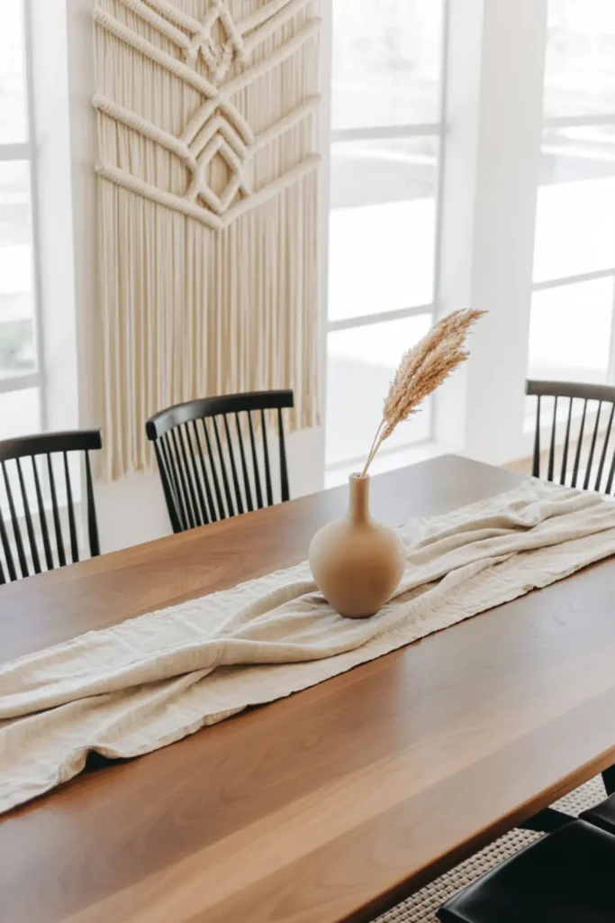 Boho dining room with cream macrame wall hanging and simple wood table