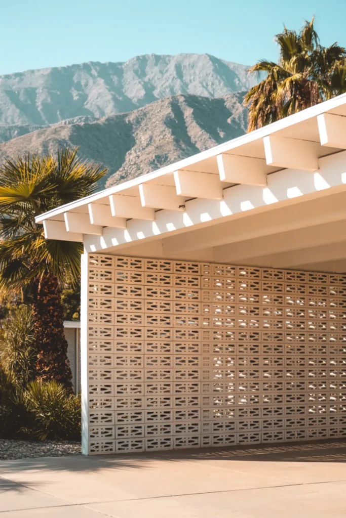 Mid-century modern flat roof carport with angled white fascia boards and decorative breeze block walls